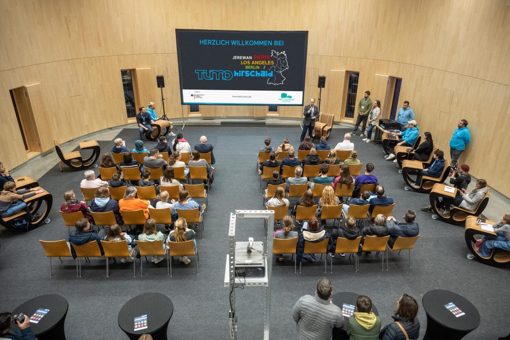 Konferenzteilnehmer in einem Auditorium bei einer Präsentation.